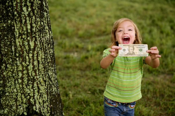 little girl holding dollar