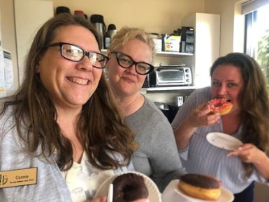 employees eating donuts in celebration of donut day